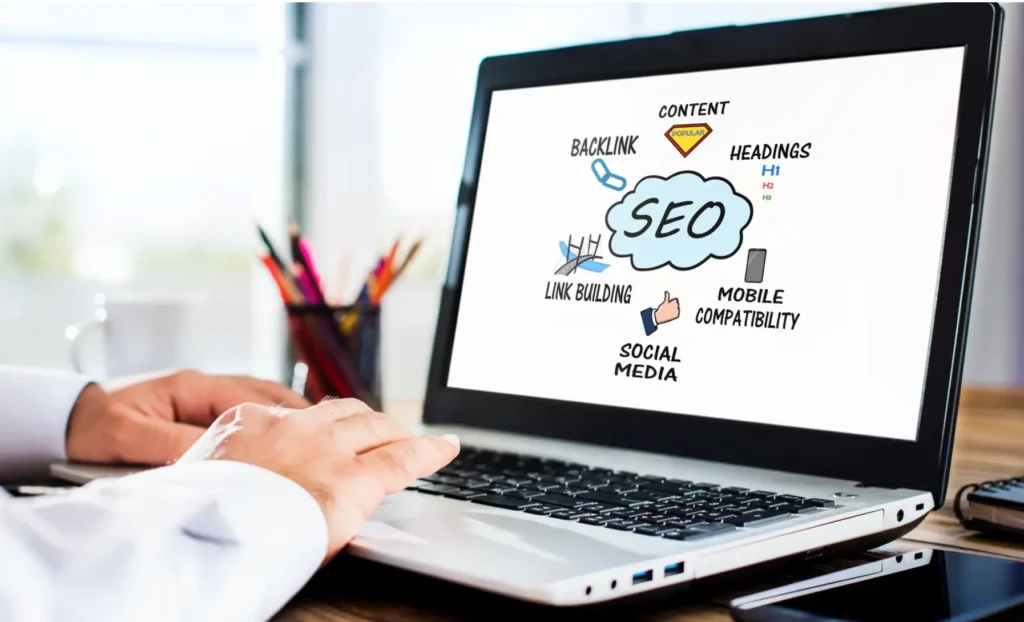 Ecran de laptop afișând pilonii SEO: backlink-uri, conținut, headings, social media și compatibilitate mobilă.